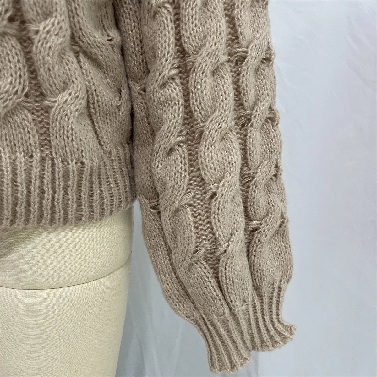 Women's loose fit O-neck sweater in taupe cable knit - closeup detail of cable knit sleeve and cuff on mannequin