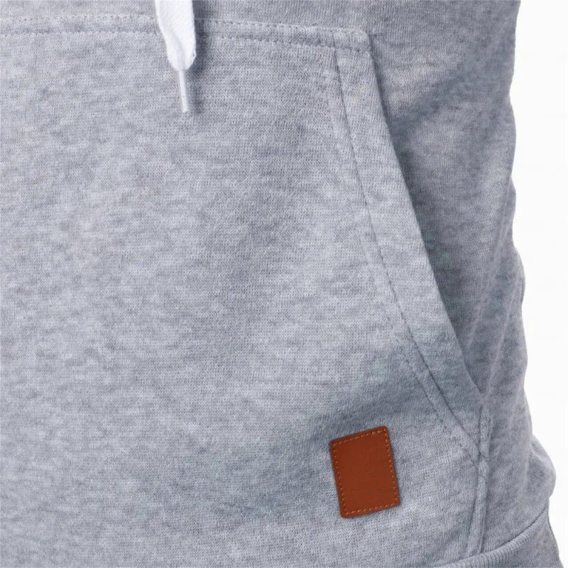 Closeup of kangaroo pocket with brown leather patch on men's lightweight light gray drawstring pullover hoodie