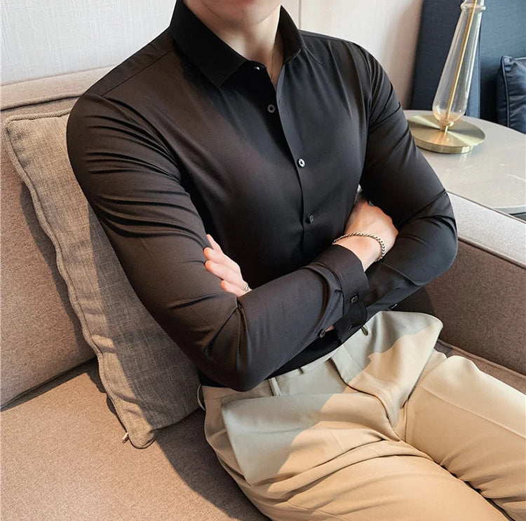 Men's slim fit dress shirt in black broadcloth long sleeve business shirt - front view arms crossed sitting
