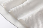 Close-up of ribbed knit texture on men's white turtleneck pullover sweater - fine fabric weave detail