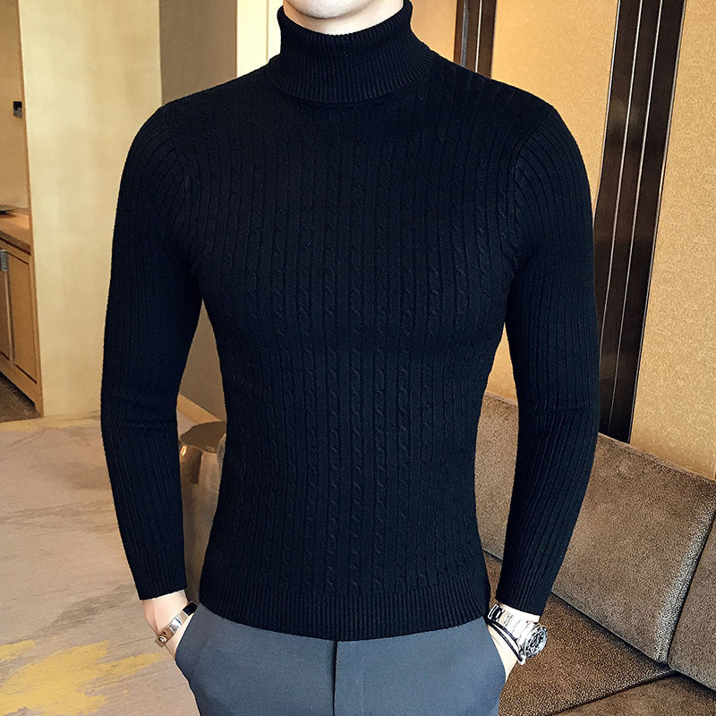 Man wearing black turtleneck cable knit pullover sweater with gray pants, lifestyle front view