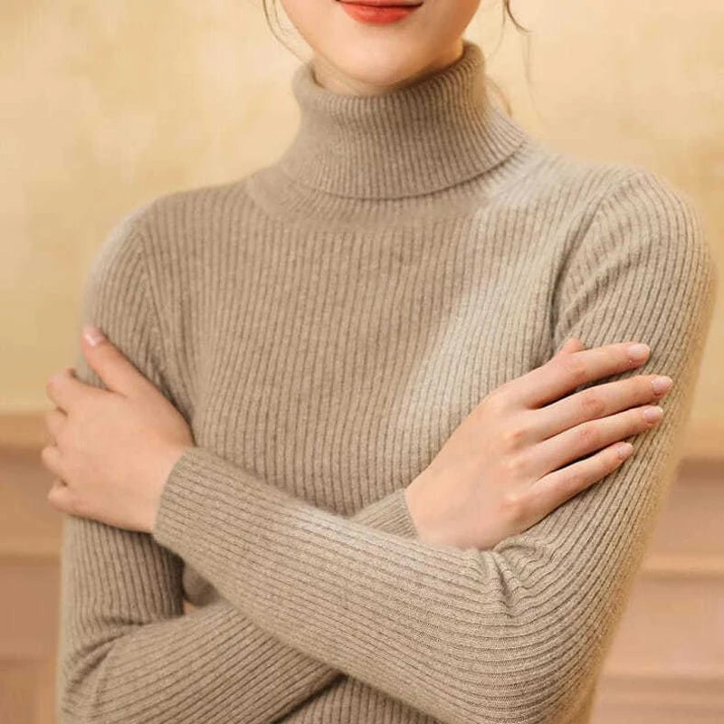 Woman wearing taupe cashmere blend ribbed turtleneck sweater with arms crossed, front view bust shot
