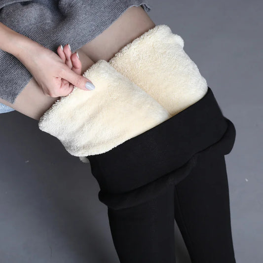 Women's high waist fleece lined thermal leggings in black, close-up showing thick cream fleece interior lining pulled down by hand