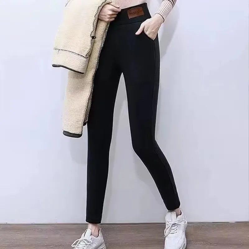 Women's high waist fleece lined thermal leggings in black, full length front view styled on model with sneakers and jacket