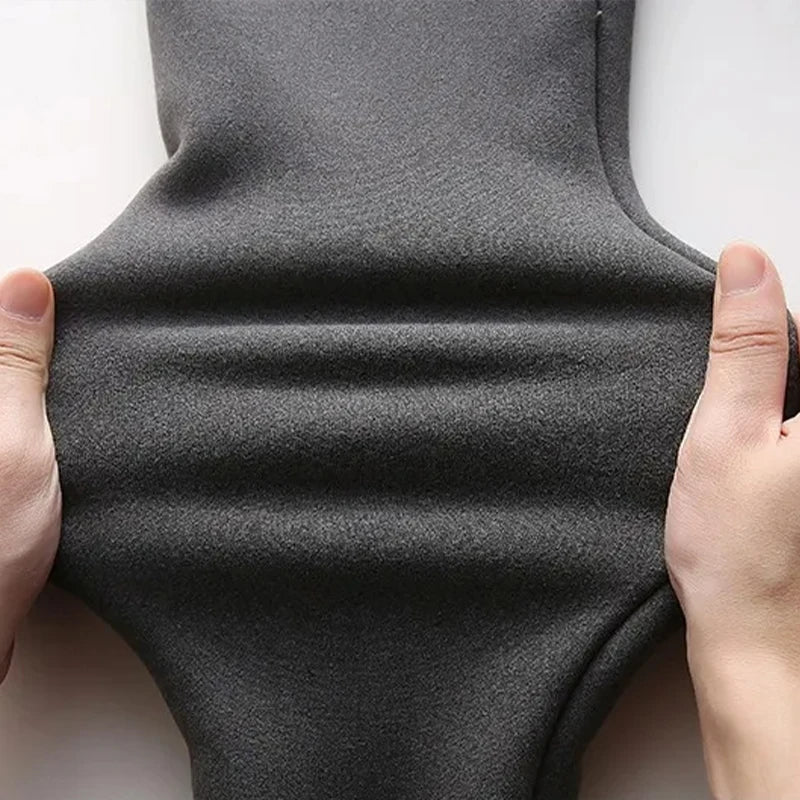 Women's high waist fleece lined thermal leggings in dark gray, close-up of exterior fabric texture held by hands showing stretch and construction