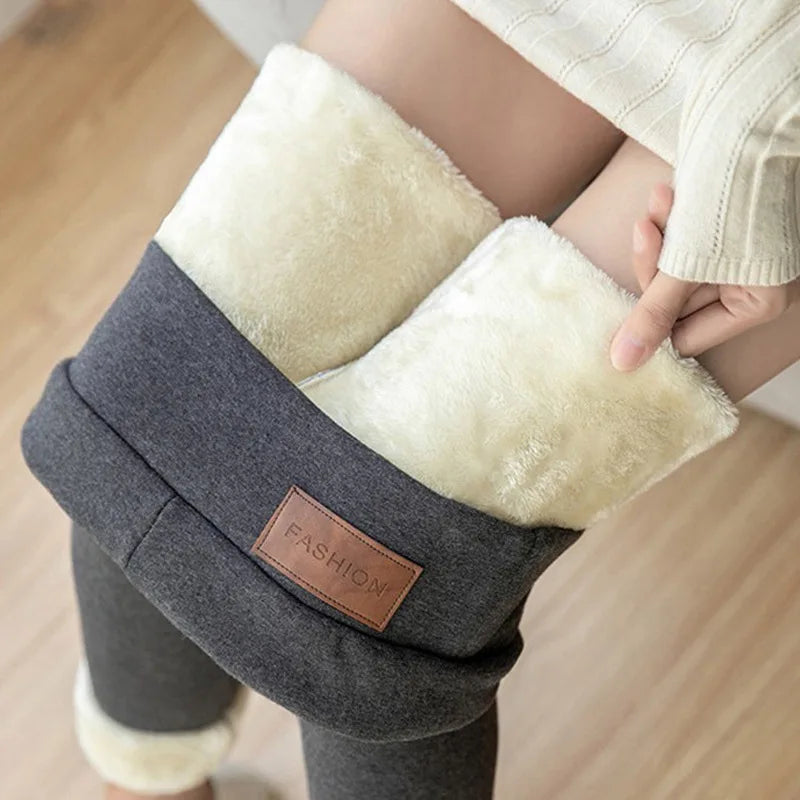 Women's high waist fleece lined thermal leggings in dark gray, close-up of waistband area showing ultra thick plush cream fleece interior lining and leather patch detail