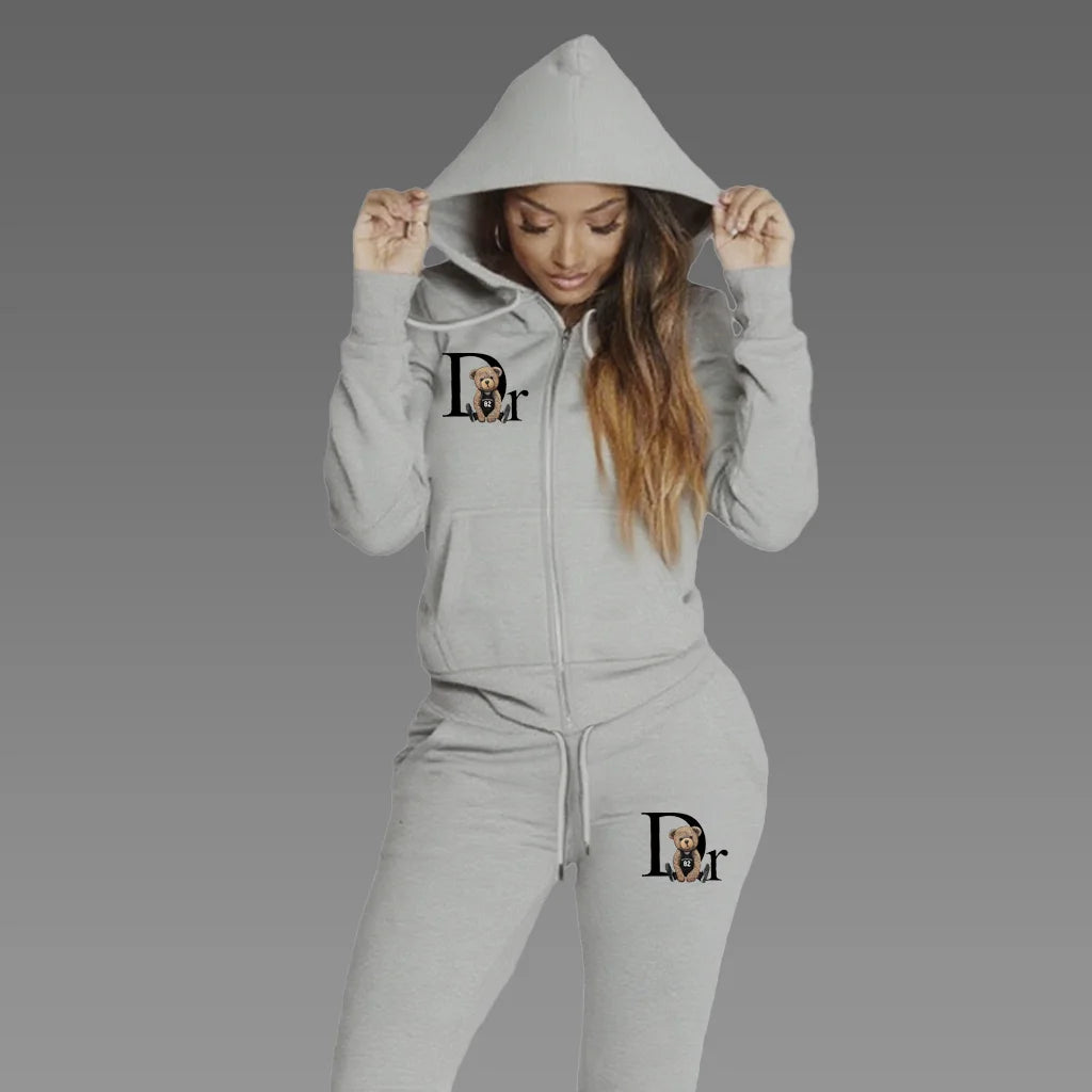 Woman wearing light gray zip-up hoodie tracksuit set with matching sport pants, front view