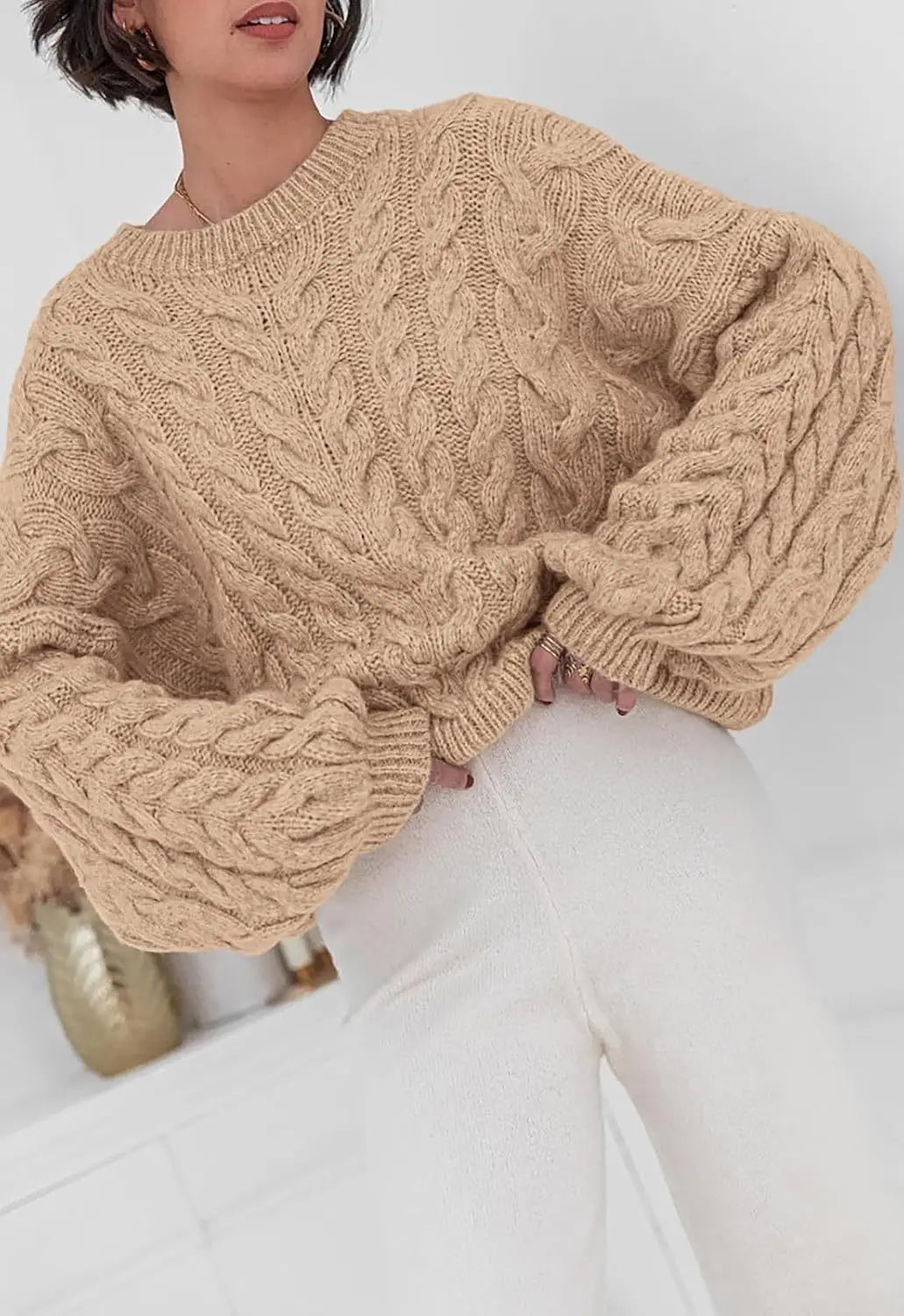 Women's loose fit O-neck sweater in beige cable knit high elastic pullover - front view seated pose
