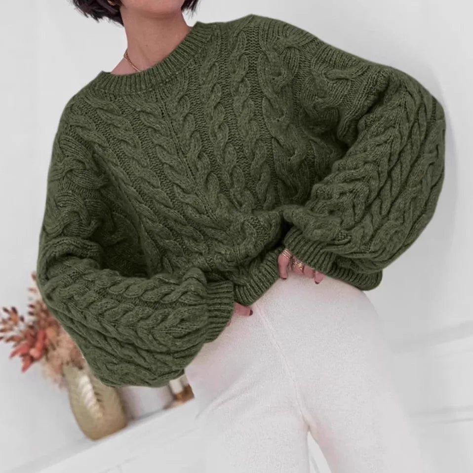 Women's loose fit O-neck sweater in olive green cable knit high elastic pullover - front view seated pose