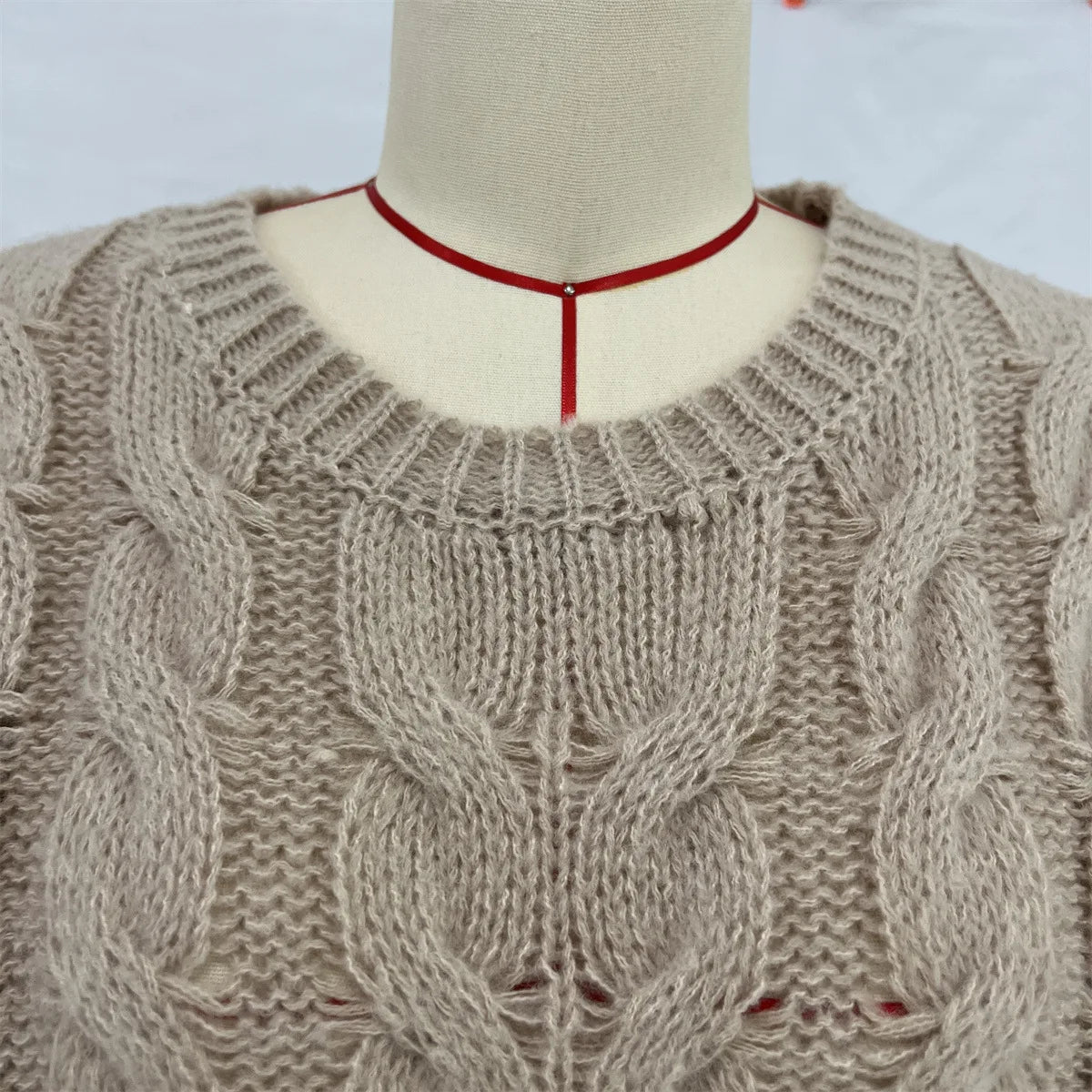 Women's loose fit O-neck sweater in taupe cable knit - closeup detail of cable knit texture and O-neck collar on mannequin