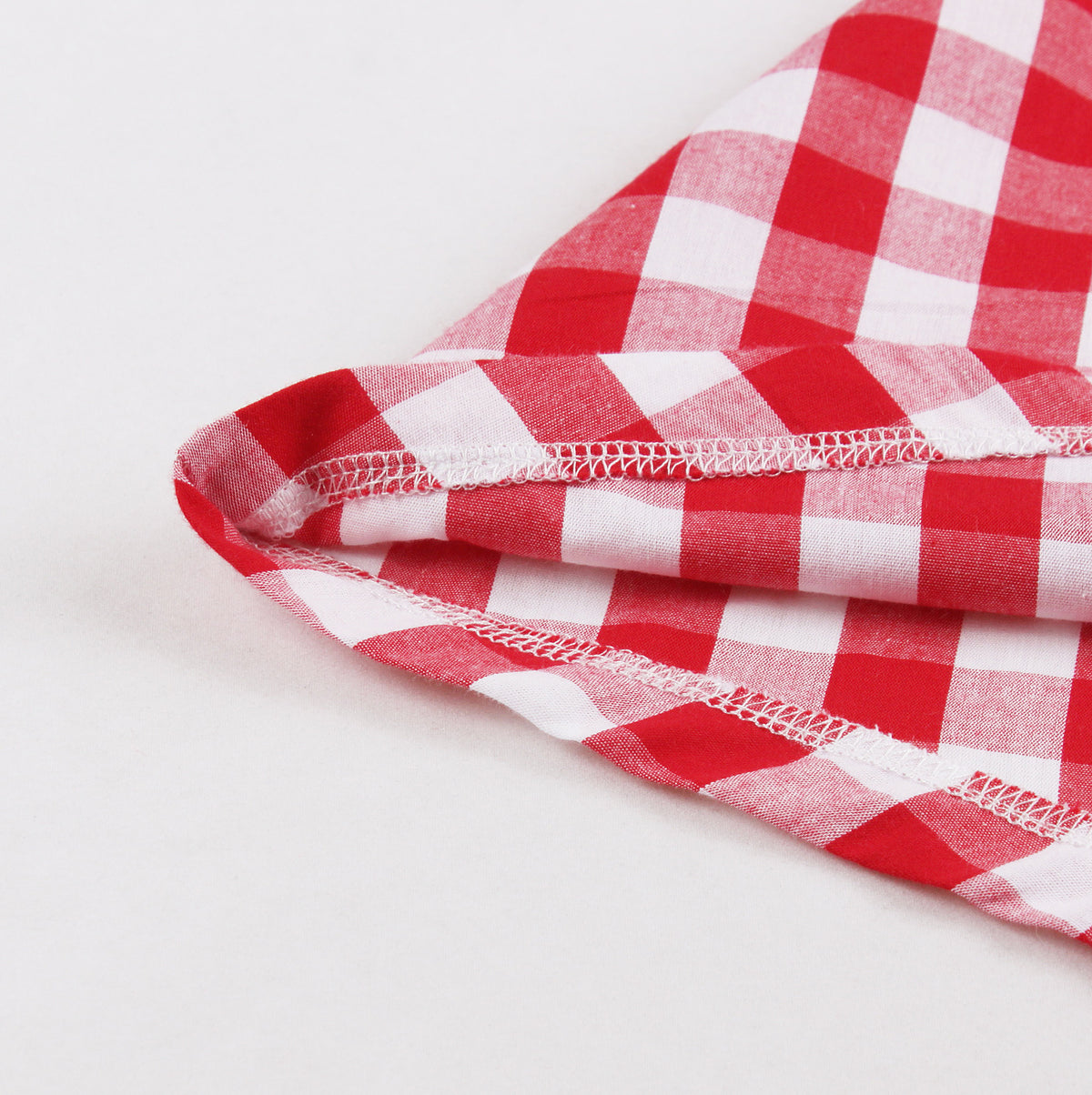 Close-up of red stitched hem edge on red and white plaid A-line dress