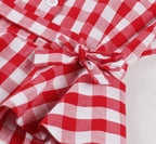 Nahaufnahme der Bindeschleife in der Taille mit Rüschendetail am rot-weiß karierten Kleid