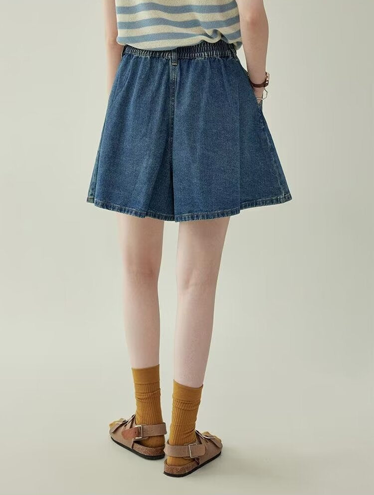 Women's wide leg pleated denim culottes in blue, back view styled on model