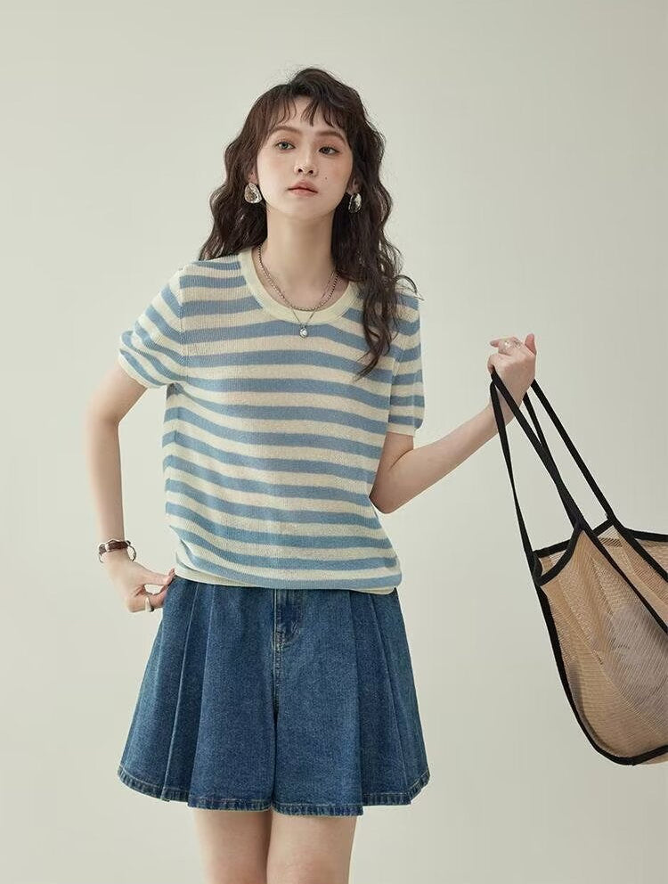 Women's wide leg pleated denim culottes in blue, full body front view styled on model with bag