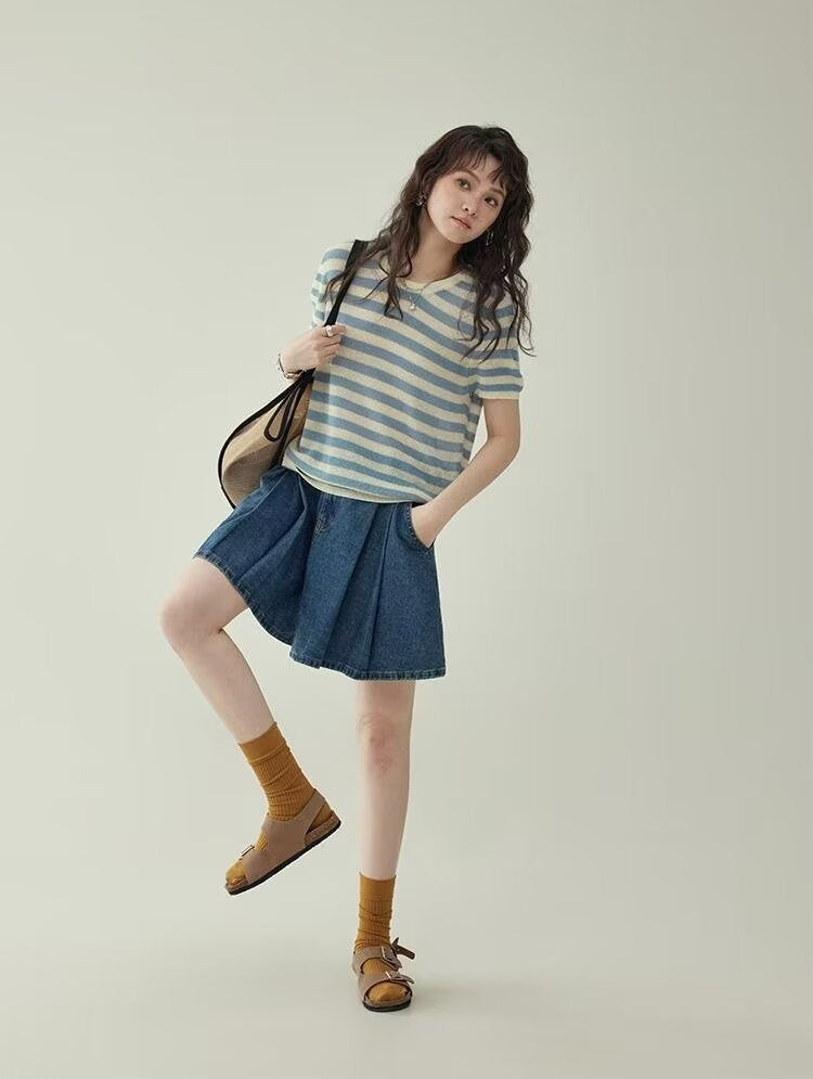 Women's wide leg pleated denim culottes in blue, full body front view styled on model in dynamic pose