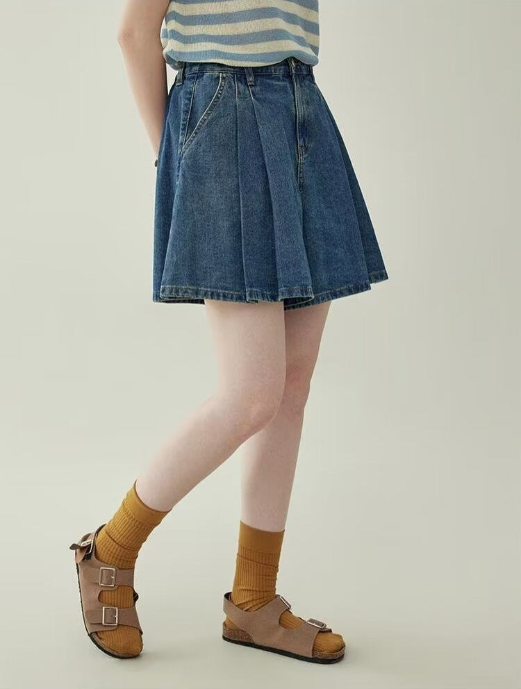 Women's wide leg pleated denim culottes in blue, side view styled on model