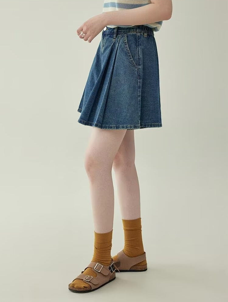 Women's wide leg pleated denim culottes in blue, side view right styled on model