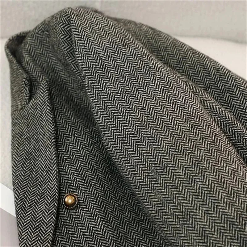 Women's slim fit blazer in gray herringbone tweed - closeup detail of fabric texture and gold button