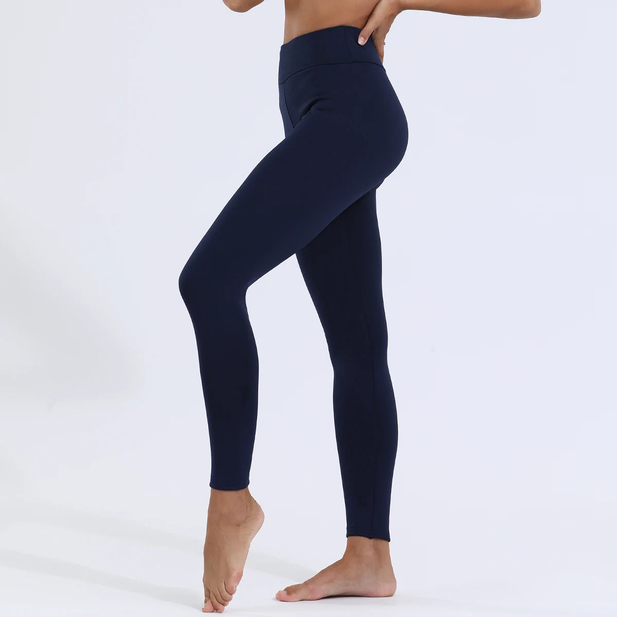 Women's high waist velvet winter leggings in navy blue, full length side view styled on model showing slim fit and high waist seam detail, barefoot