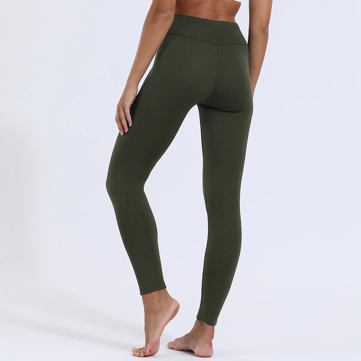 Women's high waist velvet winter leggings in olive green, full length back view styled on model showing slim fit and high waist seam detail, barefoot
