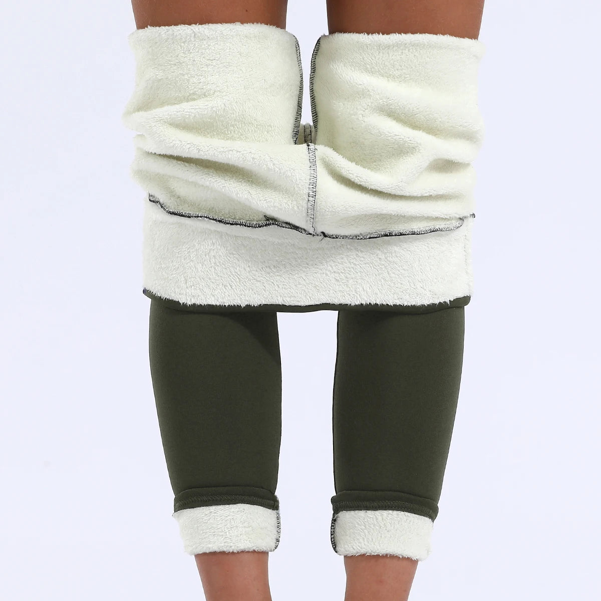 Women's high waist velvet winter leggings in olive green, front view showing both waistband and ankle cuffs rolled up revealing thick cream fleece interior lining, styled on model