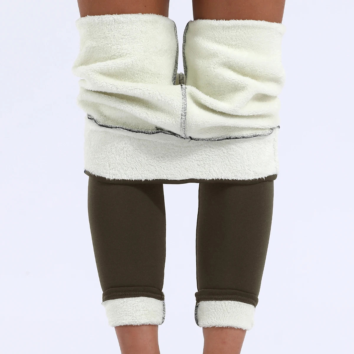 Women's high waist velvet winter leggings in olive green, front view showing both waistband and ankle cuffs rolled up revealing thick cream fleece interior lining, styled on model