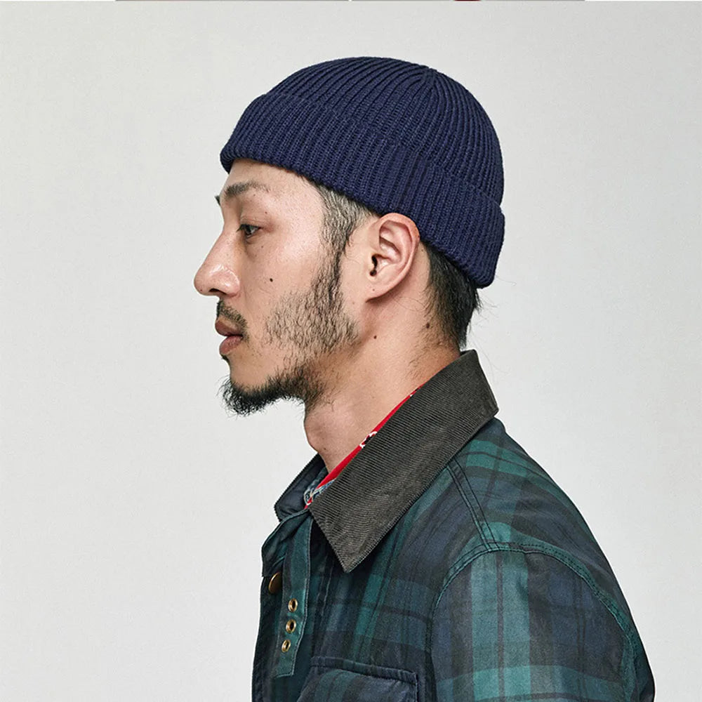 Homme portant un bonnet docker bleu marine, vue de profil