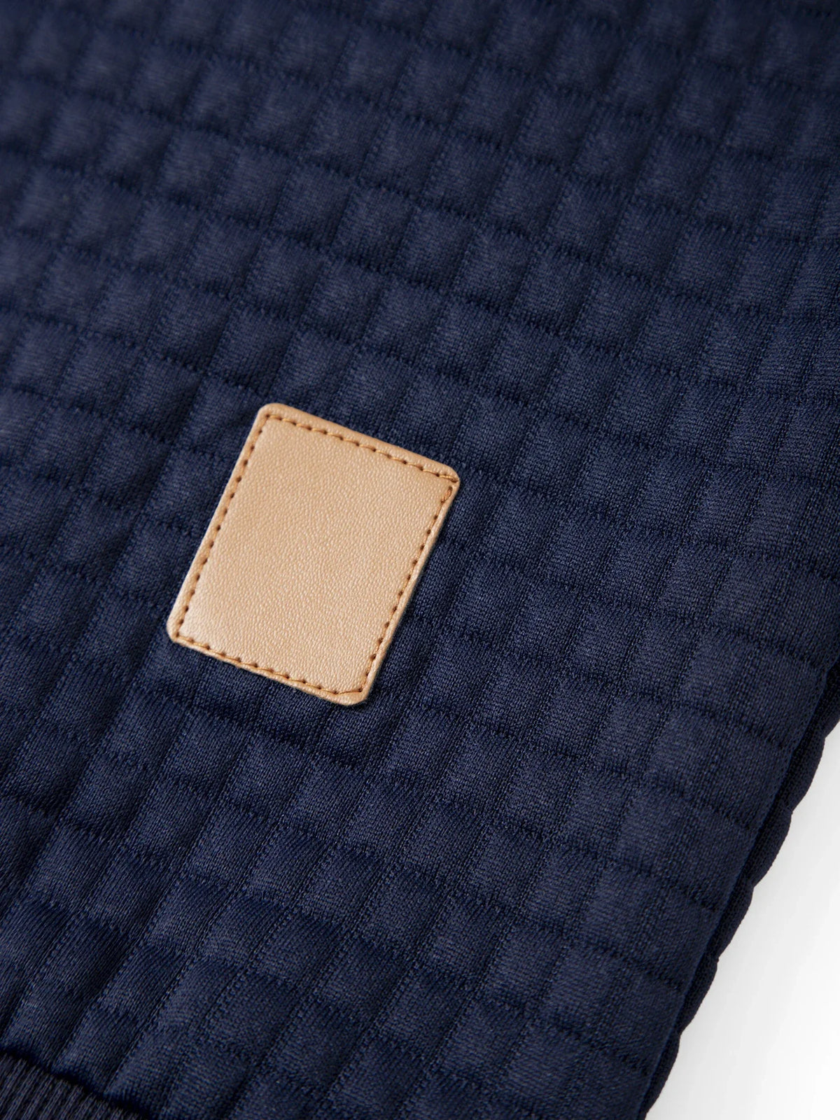 Men's waffle knit pullover hoodie, close-up of zippered chest pocket with leather pull tab