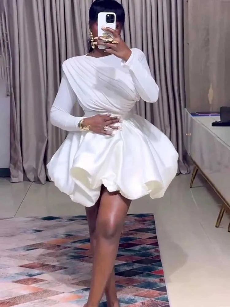 Woman wearing white puff sleeve bubble hem mini dress, full length view