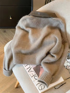 Kurze Damen-Strickjacke mit Reißverschluss in Grau mit braunem Kunstlederkragen, Rückansicht
