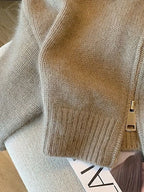 Nahaufnahme von Reißverschluss-Zipper und Rippbündchen an der kurzen grauen Strickjacke