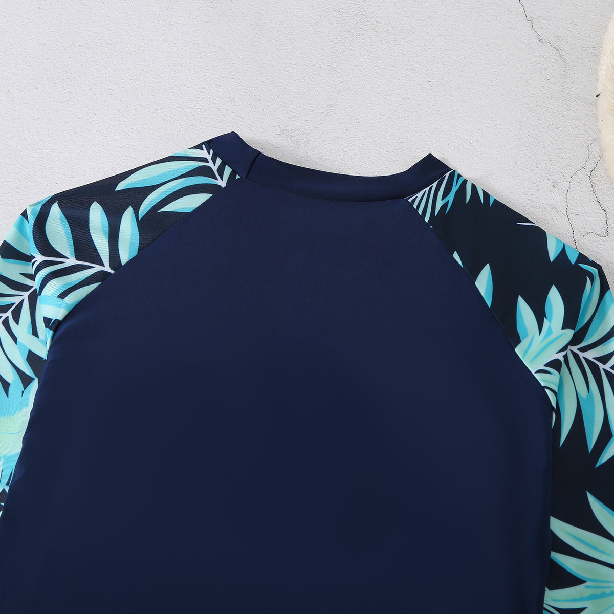 Women's navy blue tropical rash guard top, back view